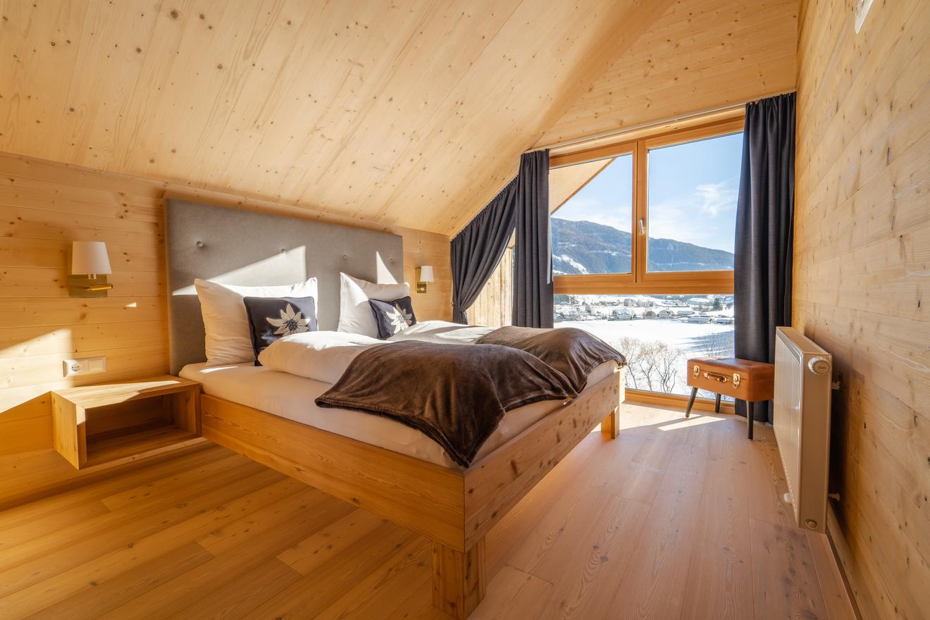 Schlafzimmer mit Panoramafenster und Bergpanorama